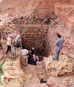 Außenkammer der Gruftanlagen, die von hohen Steinmauern umgeben ist. Am Grunde dieser schachtartigen Kammer liegt der Eingang in die in den Felsen geschlagenen Grabkammern. Die Außenkammer lag unter 8 Meter hoch anstehenden Schuttmassen verborgen, die durch die eingestürzten Mauern des Königspalastes entstanden waren. (Photo: Konrad Wita, Berlin)